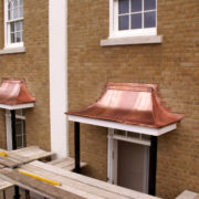 Bright copper porch canopy, HRH Prince Charles buildings, Poundbury, Dorchester © Mike White Ltd